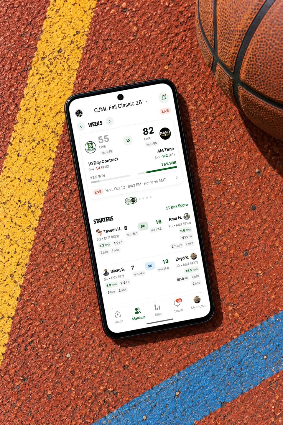 GameGrid live basketball score on an Android phone lying on an outdoor court