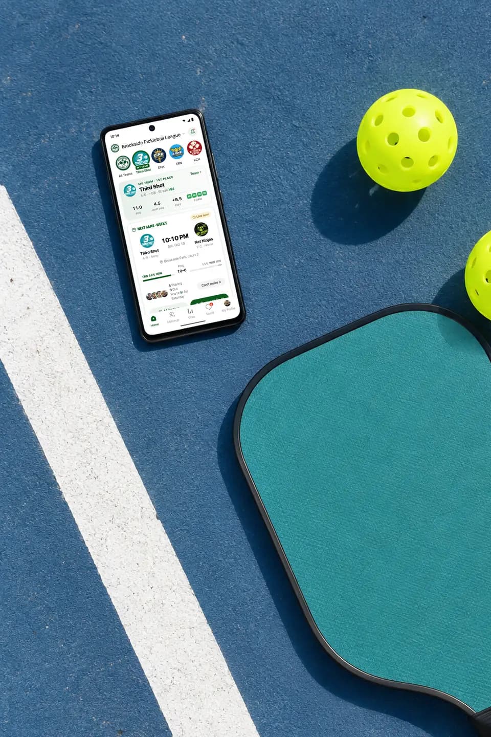 GameGrid on an Android phone on a pickleball court beside a paddle